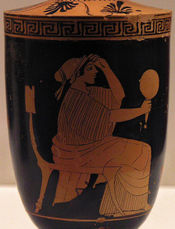 Greek vase with image of a woman looking in a hand mirror