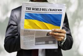 Person reading newspaper about Ukraine war